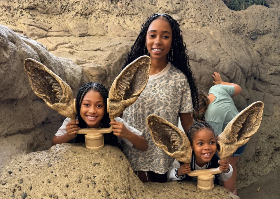 Girls with playful smiles at the rock exhibit