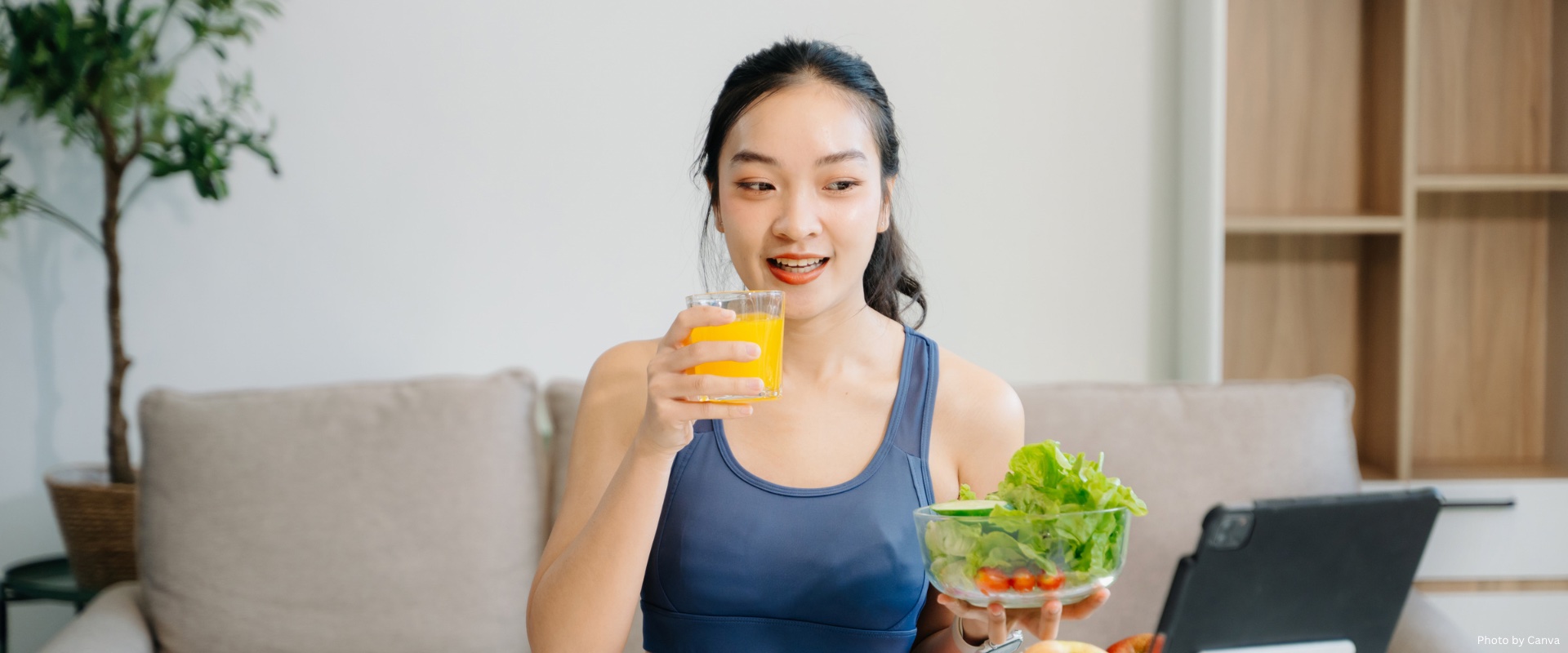Female eating healthy while working on a laptop
