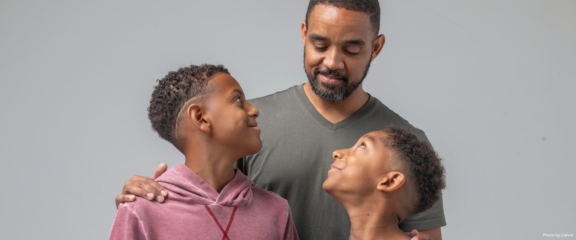 Two Young Sons Looking up to Their African American Father
