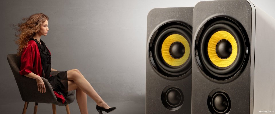 Young lady listening to big loudspeakers