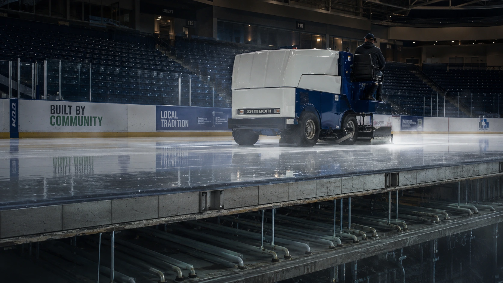 An ice technician driving an ice resurfacer across a rink